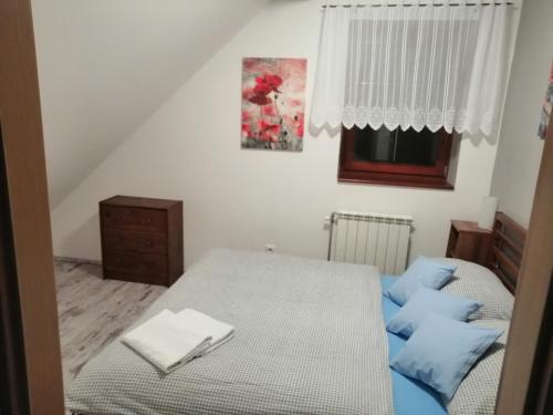 ヴァルチツェにあるApartment Železný Hrozenのベッドルーム1室(青い枕のベッド1台、窓付)