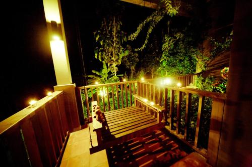 a porch with a wooden bench with lights on it at Phukumhom Khao Yai in Wangkata