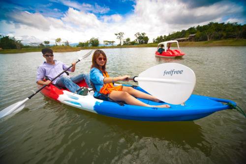 two people riding on a paddle boat on the water at Phukumhom Khao Yai in Wangkata