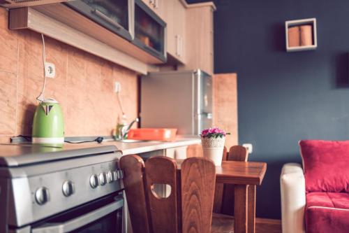 a kitchen with a stove and a table in a room at Square Vanilla Apartments in Skopje