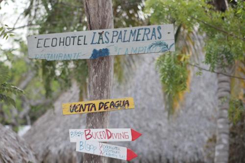 a street sign with several signs on a pole at Eco Hotel Las Palmeras in Isla Grande