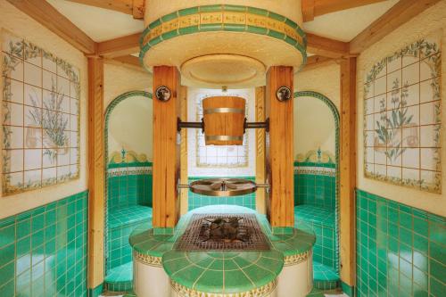a bathroom with green tiled walls and a sink at Berg-Spa & Hotel Zamangspitze in Sankt Gallenkirch