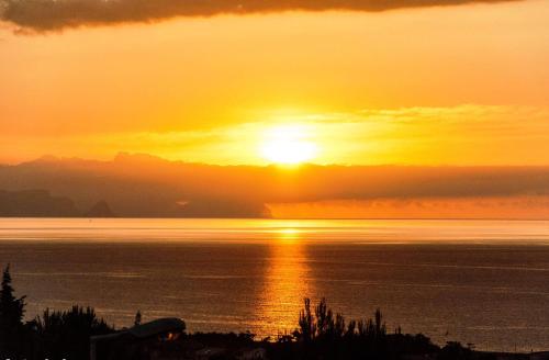 a sunset over the water with the sun setting at IN CENTRO ROOMS Vicino Cefalù SELF-CHEK-IN in Campofelice di Roccella