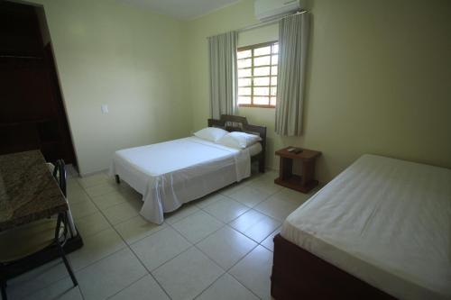 ein Hotelzimmer mit 2 Betten und einem Fenster in der Unterkunft Mosaico Hotel in Dianópolis