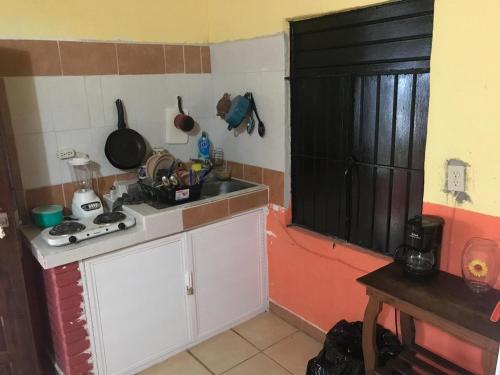 a small kitchen with a sink and a stove at Cabaña Quiahuiztlán Playa Villa Rica in Laguna Verde