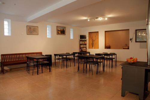 a dining room with tables and chairs and a bench at Casas do Rio in Pampilhosa da Serra