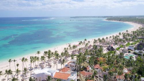 an aerial view of a beach with palm trees and the ocean at Tropical Villas at Los Corales Beach - Caribbean Rentals FZCO in Punta Cana
