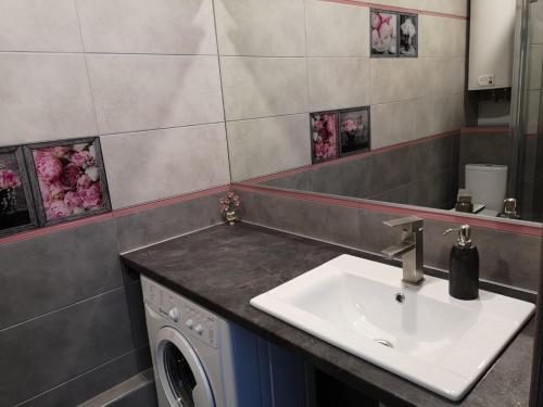 a bathroom with a sink and a washing machine at Элитная квартира в Аркадии с видом на море 26 Жемчужина in Odesa