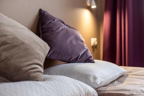 a bed with two pillows on top of it at Bestes apartamenti in Kocēni