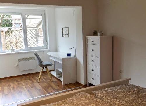 a bedroom with a desk and a chair and a window at Paradies Für Zwei in Frauenkirchen