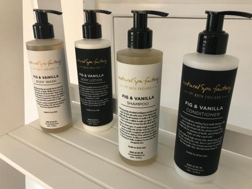 a group of four shampoo bottles sitting on a shelf at Ye Olde Saddlery B&B in Neatishead