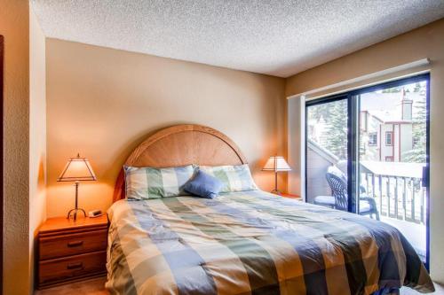 a bedroom with a bed and a balcony at Winterpoint 21 in Breckenridge