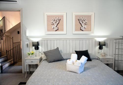 シャッカにあるベッド＆ブレックファースト コンテ ルナのベッドルーム1室(ベッド1台、テーブル2台、壁に2枚の写真付)