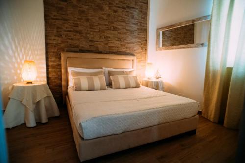 a bedroom with a bed and a brick wall at The Lighthouse in Trappeto
