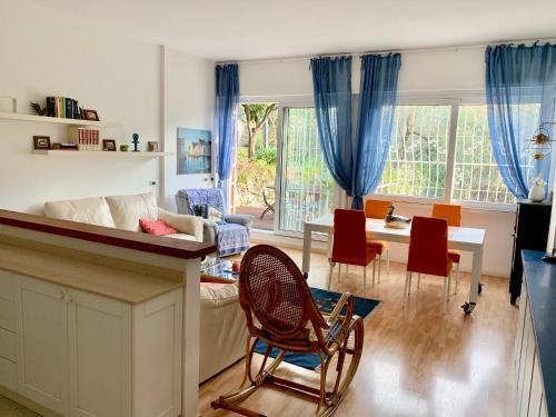 uma sala de estar com um sofá, uma mesa e cadeiras em Il Nido tra gli Ulivi em Rapallo
