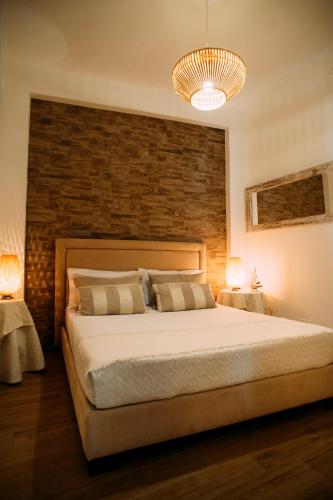 a bedroom with a large bed and a brick wall at The Lighthouse in Trappeto