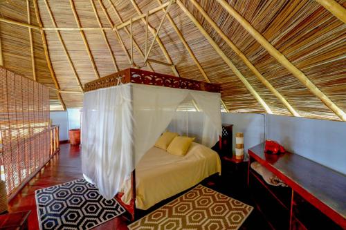 ein Schlafzimmer mit einem Himmelbett in einem Zimmer in der Unterkunft Punta Caracol Acqua Lodge in Bocas del Toro