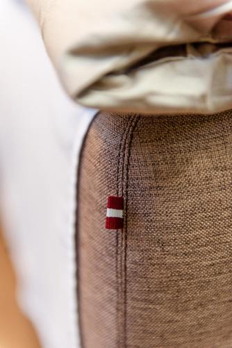 a red and white button on the side of a pocket at Bestes apartamenti in Kocēni