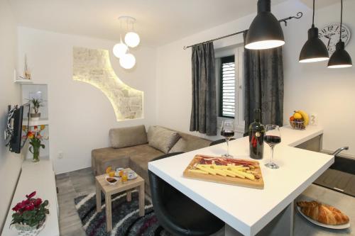 a kitchen and living room with a table and glasses of wine at Apartment Luigi in Split