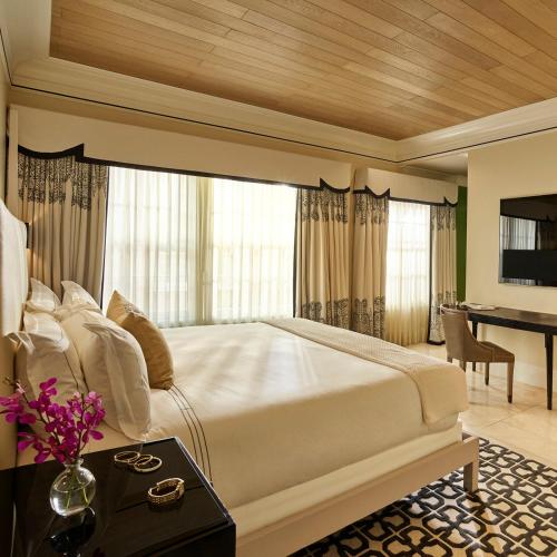 a bedroom with a large white bed and a desk at Hotel Bel-Air - Dorchester Collection in Los Angeles