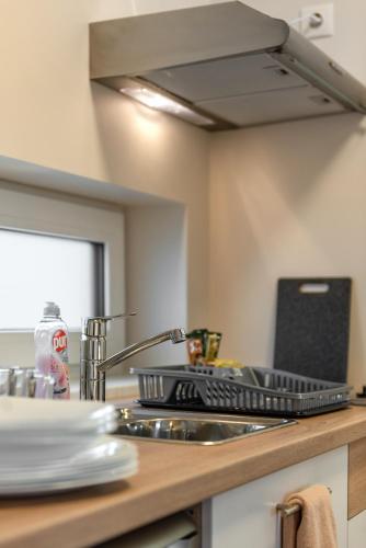 a kitchen counter with a sink and a stove top oven at Bestes apartamenti in Kocēni