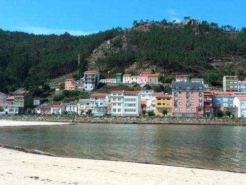 a group of houses on a hill next to the water at Casa rural Camelle Casa dos avós in Camariñas