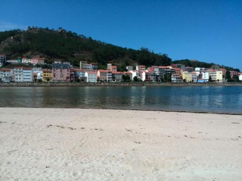 a group of buildings on the shore of a body of water at Casa rural Camelle Casa dos avós in Camariñas