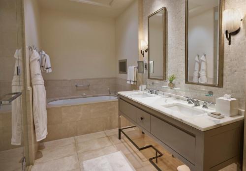 a bathroom with two sinks and a bath tub at Hotel Bel-Air - Dorchester Collection in Los Angeles