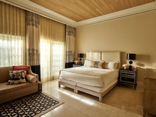 a bedroom with a bed and a couch at Hotel Bel-Air - Dorchester Collection in Los Angeles