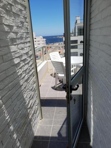 a door to a balcony with a table and chairs at Vendaval 301 in Punta del Este