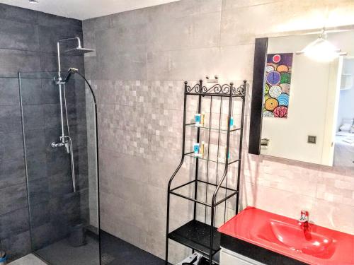 a bathroom with a shower and a red sink at Sol Hospital Santiago in Úbeda