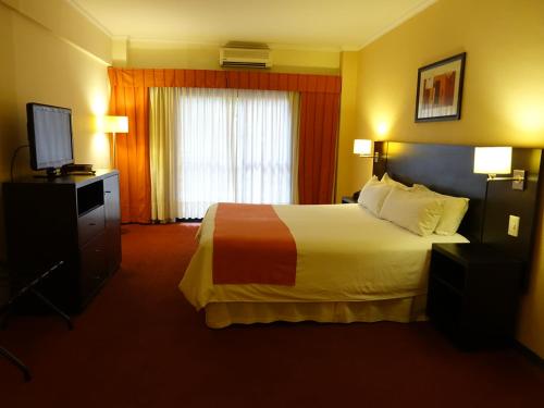 a hotel room with a bed and a television at Duomi Hotel Buenos Aires in Buenos Aires