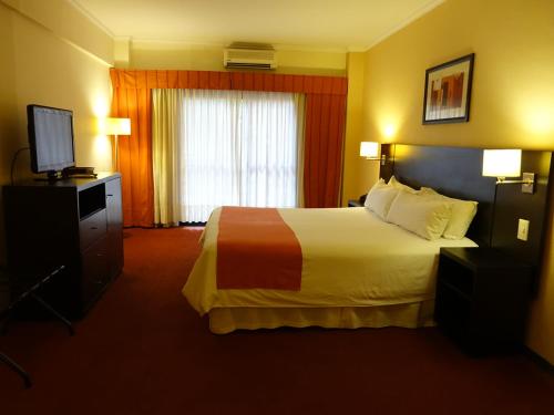 een hotelkamer met een bed en een televisie bij Duomi Hotel Buenos Aires in Buenos Aires