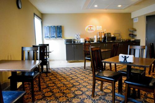 a dining room with tables and chairs in a restaurant at Super 8 by Wyndham Fox Creek in Fox Creek