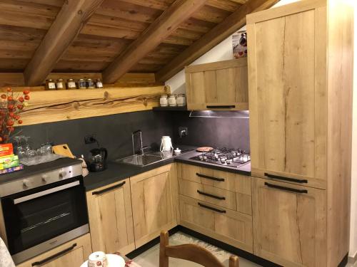 a kitchen with wooden cabinets and a stove top oven at Au Coin Du Chateau in Châtillon