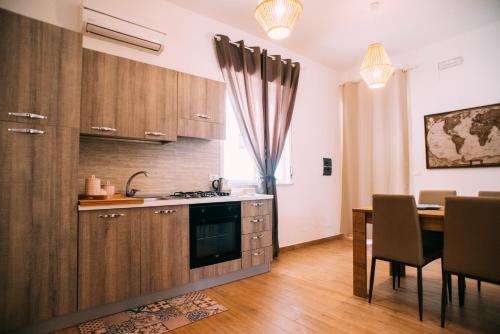 a kitchen with wooden cabinets and a table and a dining room at The Lighthouse in Trappeto