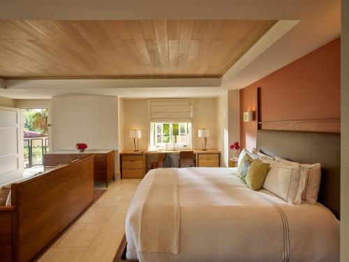 a bedroom with a large bed and a desk at Hotel Bel-Air - Dorchester Collection in Los Angeles
