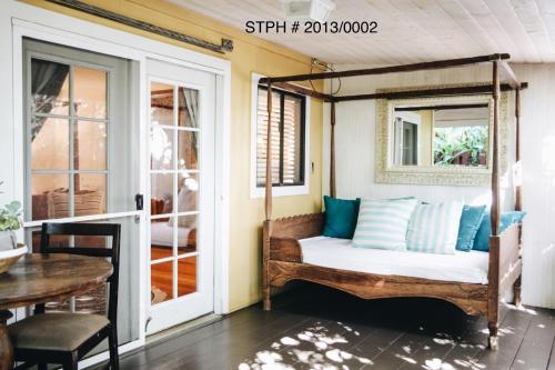 a porch with a bed in a room at Paia Inn in Paia