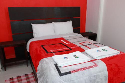 a red and white bed with two towels on it at Hotel Boutique Otomi cerca de Tolantongo in Cardonal