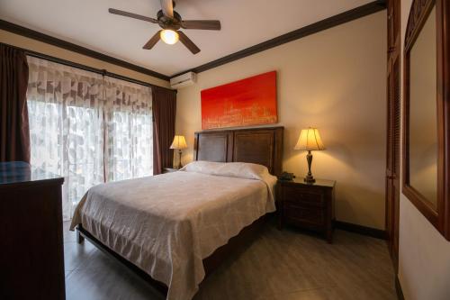 a bedroom with a bed and a ceiling fan at Club del Mar Oceanfront in Jacó