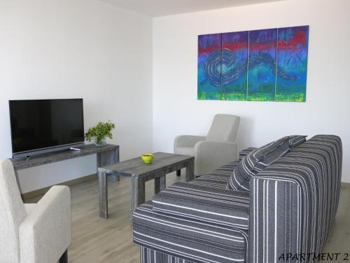 een woonkamer met een bank en een tv bij Apartments Luka in Trogir