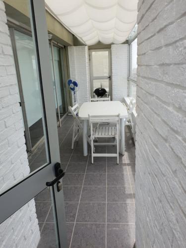 a balcony with a table and a cat sitting on a chair at Vendaval 301 in Punta del Este