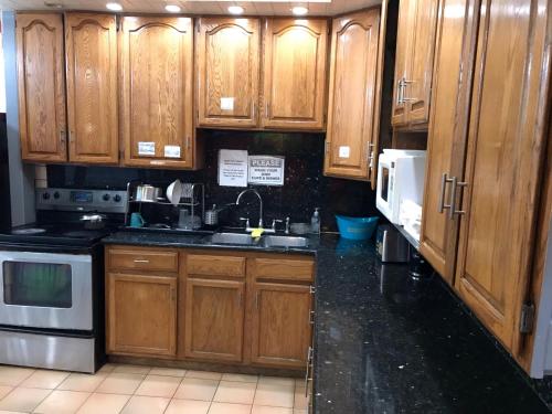 a kitchen with wooden cabinets and a black counter top at European Hostel in San Francisco