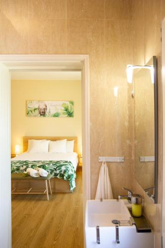 a bedroom with a bed and a sink and a mirror at Villa Prana Guesthouse, Yoga & Ayurveda in Portimão