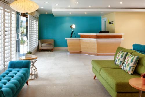 a lobby with blue walls and a green couch at Movie Colony Hotel - Adults Only in Palm Springs