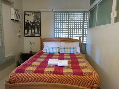 a bedroom with a bed with two towels on it at The Duyan House at Sinagtala Resort in Orani