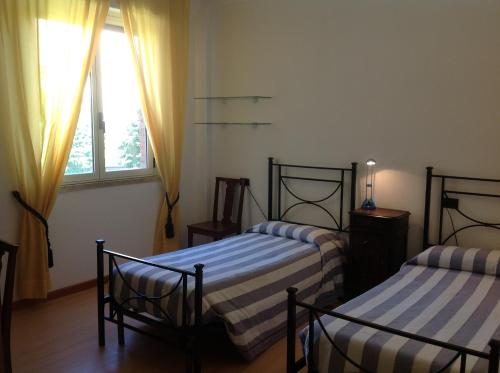 a bedroom with two beds and a window at Ospitalità San Tommaso d'Aquino in Bologna