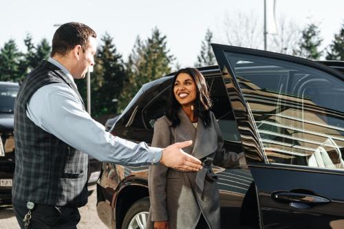 a man and a woman standing next to a car at Fairmont Vancouver Airport In-Terminal Hotel in Richmond