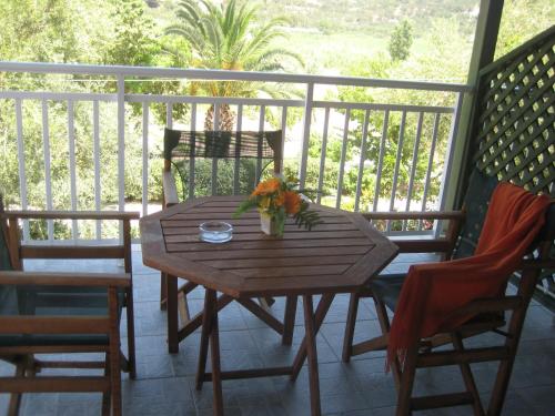a wooden table on a porch with two chairs and a table at Maria Studios in Keri