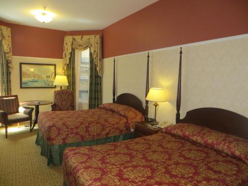 a hotel room with two beds and a table at Carleton of Oak Park in Oak Park